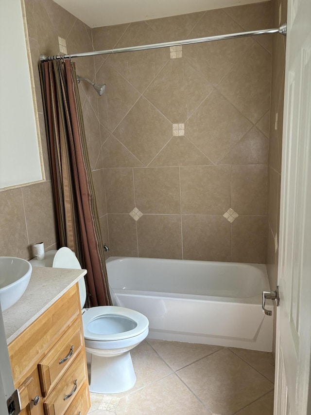 bathroom featuring vanity, shower / bath combo with shower curtain, tile patterned floors, toilet, and tile walls