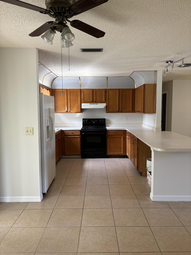 kitchen with black electric range, under cabinet range hood, white fridge with ice dispenser, brown cabinetry, and light tile patterned floors