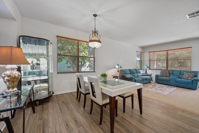 dining room with visible vents, baseboards, and wood finished floors