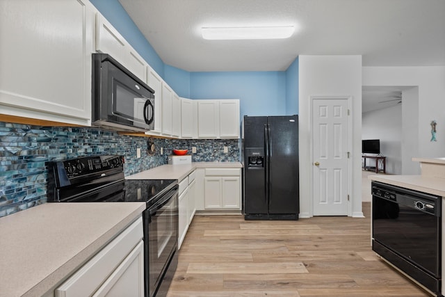 kitchen with black appliances, light wood-style flooring, backsplash, white cabinetry, and light countertops