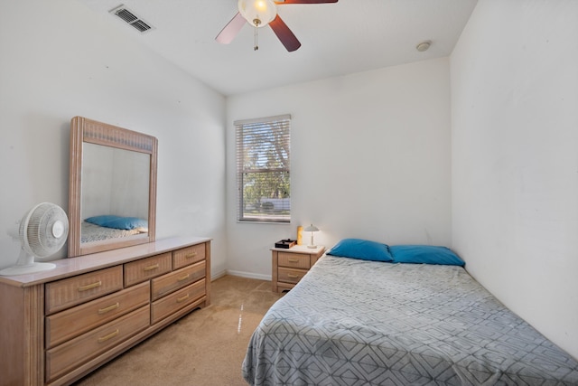 bedroom featuring a ceiling fan, visible vents, and light carpet