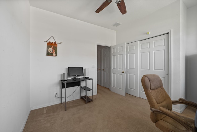 home office featuring baseboards, a ceiling fan, visible vents, and light carpet