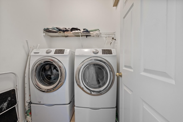 clothes washing area featuring laundry area, heating unit, and washing machine and dryer