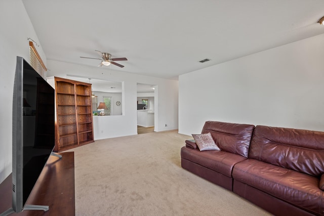 carpeted living room featuring visible vents, baseboards, and ceiling fan