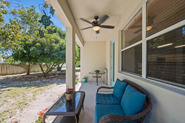 view of patio / terrace with a porch, a ceiling fan, and fence