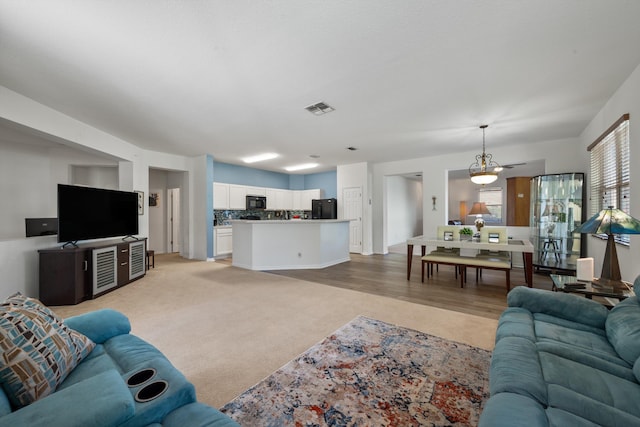 living room with visible vents and light colored carpet