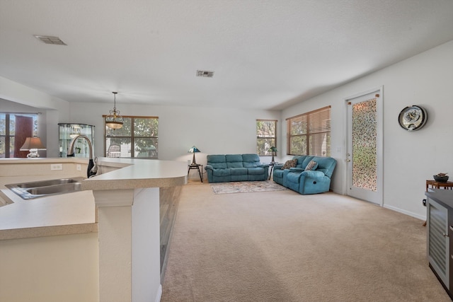 living area featuring visible vents, light colored carpet, and a healthy amount of sunlight