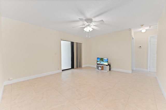 empty room with light tile patterned floors, baseboards, and ceiling fan