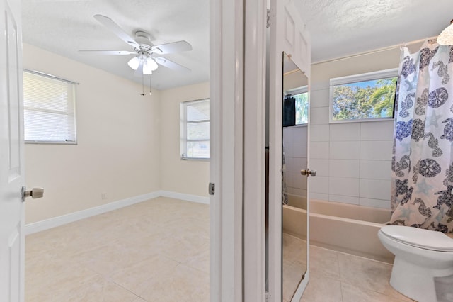 bathroom featuring tile patterned flooring, toilet, a healthy amount of sunlight, and baseboards