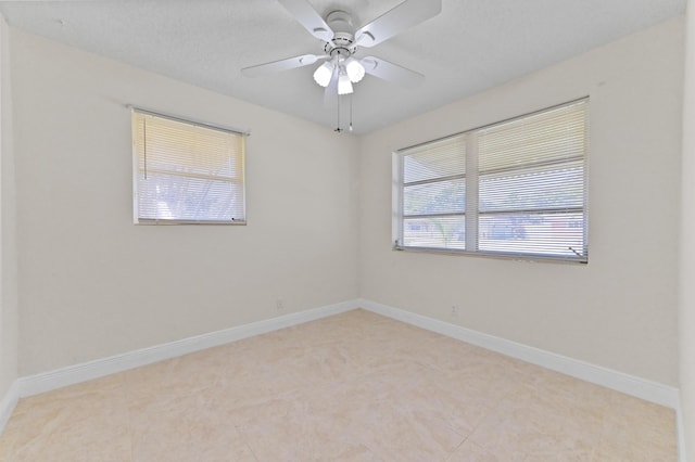 spare room with baseboards and ceiling fan