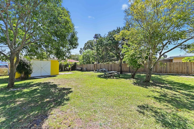 view of yard featuring a fenced backyard, a storage shed, and an outdoor structure