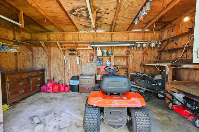 garage with a workshop area and wood walls