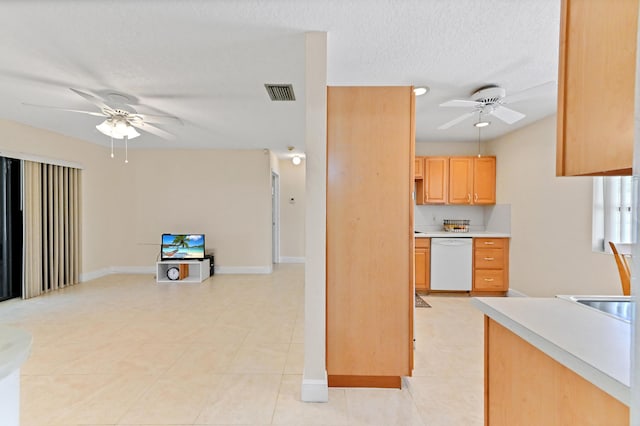 kitchen featuring visible vents, light countertops, white dishwasher, a textured ceiling, and a ceiling fan