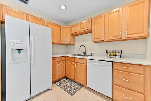 kitchen featuring light brown cabinets, a sink, white appliances, light countertops, and light tile patterned floors