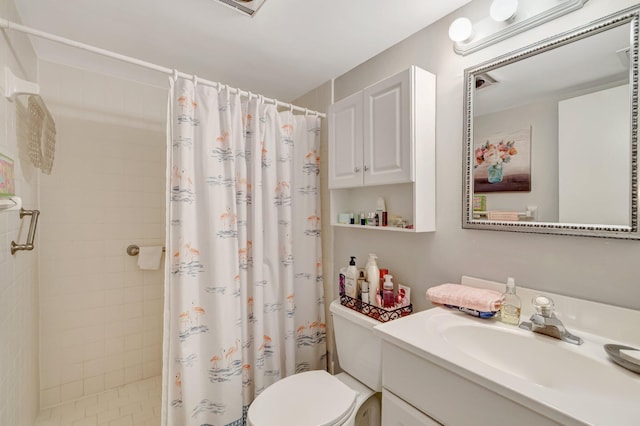 bathroom featuring tiled shower, toilet, and vanity