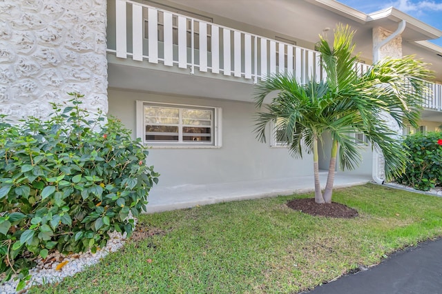 view of side of property featuring stucco siding and a lawn