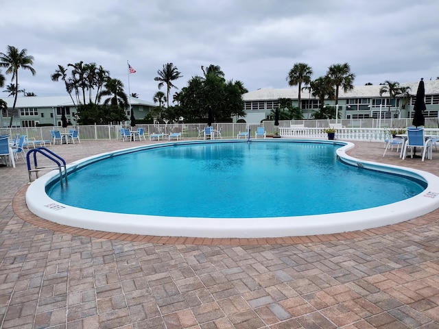 view of swimming pool with a patio area and fence