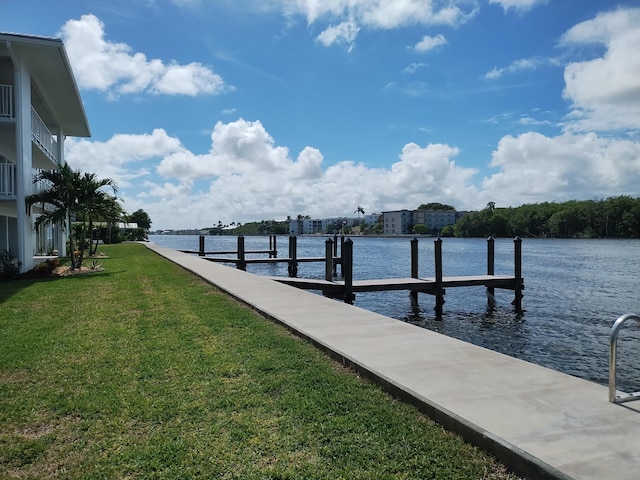 dock area with a water view and a lawn