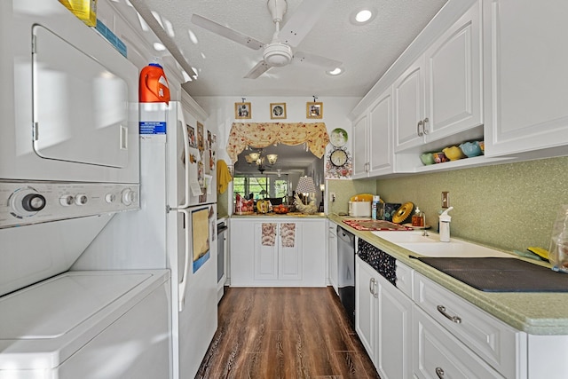 kitchen featuring stainless steel dishwasher, white cabinetry, stacked washing maching and dryer, ceiling fan, and dark wood-style flooring