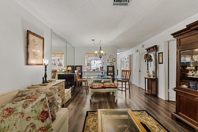 dining space with a chandelier, visible vents, a textured ceiling, and dark wood-style floors