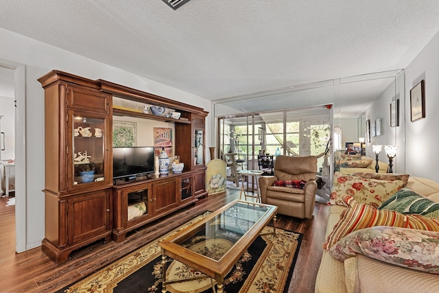 living area featuring a textured ceiling and dark wood-style flooring