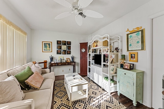 living room featuring dark wood-type flooring and a ceiling fan