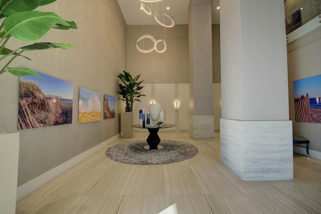 hallway with baseboards and a high ceiling