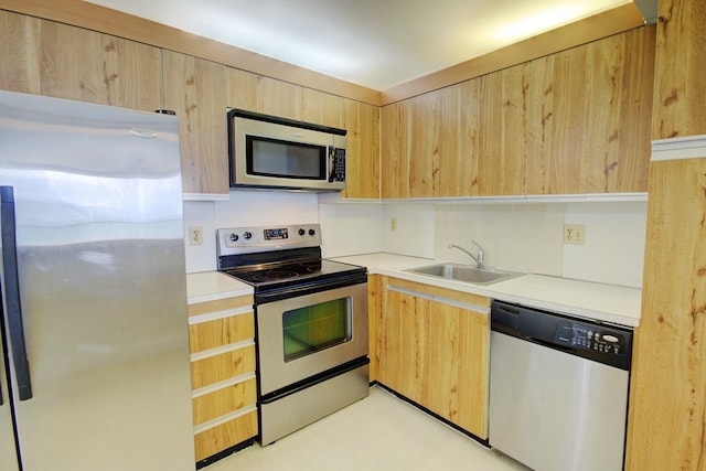 kitchen featuring light countertops, light brown cabinets, appliances with stainless steel finishes, and a sink