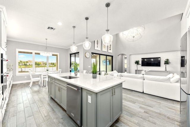 kitchen with visible vents, arched walkways, gray cabinets, a sink, and a notable chandelier