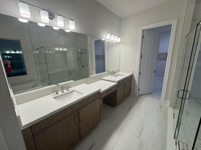 full bathroom featuring double vanity, marble finish floor, a marble finish shower, and a sink