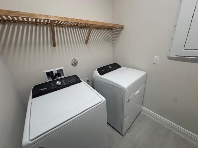 laundry room with electric panel, baseboards, laundry area, and washing machine and clothes dryer