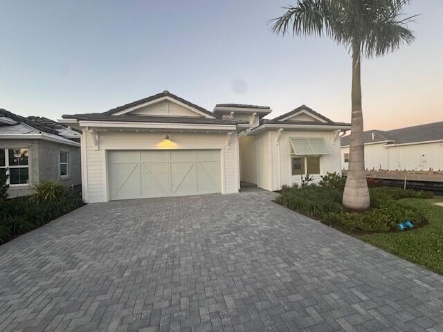 view of front of house with decorative driveway and a garage