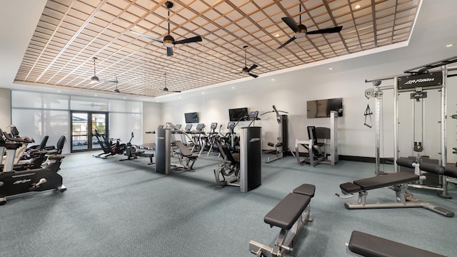 workout area featuring recessed lighting, baseboards, a tray ceiling, and a ceiling fan