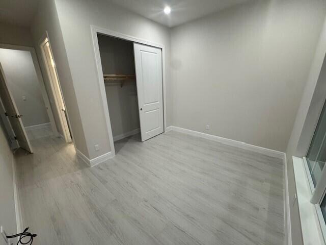 unfurnished bedroom featuring recessed lighting, a closet, baseboards, and light wood-style floors