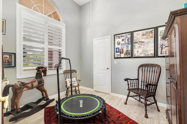 recreation room featuring light wood-style floors and baseboards