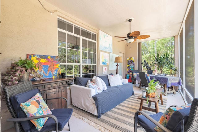 sunroom featuring an outdoor living space, healthy amount of natural light, and a ceiling fan