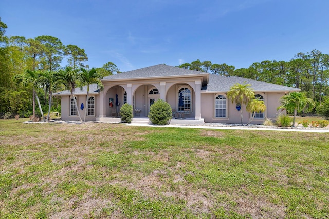 mediterranean / spanish-style house with stucco siding, a front yard, and a porch