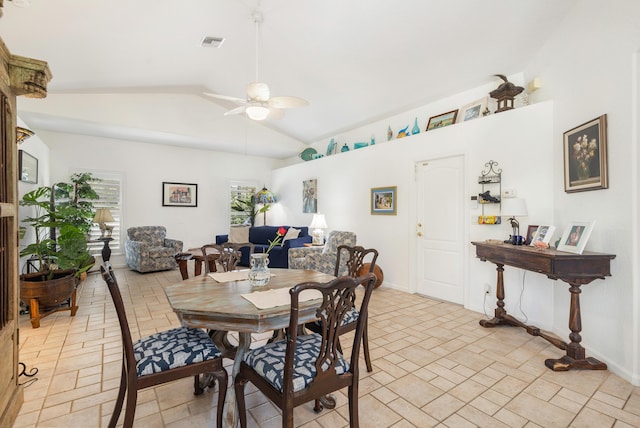 dining room featuring a ceiling fan, lofted ceiling, stone tile flooring, and baseboards