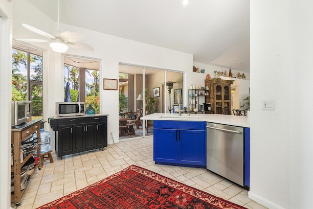 kitchen with stainless steel appliances, light countertops, ceiling fan, a sink, and a peninsula