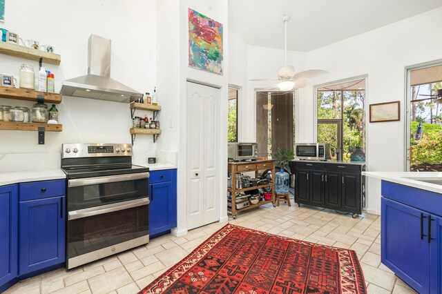 kitchen featuring wall chimney exhaust hood, appliances with stainless steel finishes, open shelves, blue cabinetry, and light countertops