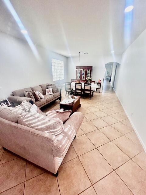 living area featuring light tile patterned floors and arched walkways