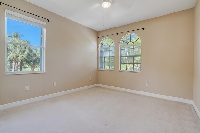 unfurnished room with a wealth of natural light, baseboards, and carpet floors