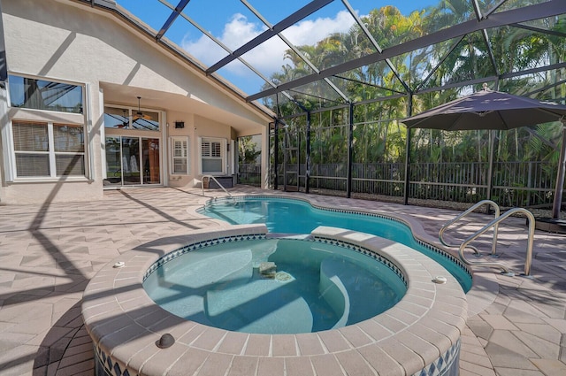 view of swimming pool with a ceiling fan, a pool with connected hot tub, a patio, fence, and glass enclosure