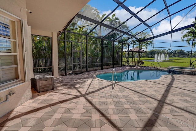 view of pool with a lanai, a pool with connected hot tub, and a patio