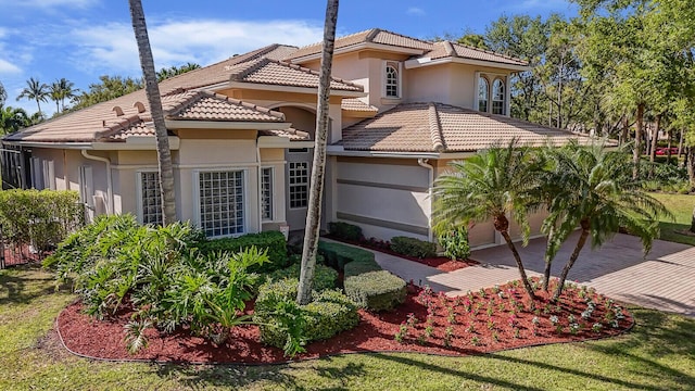 view of front facade featuring stucco siding, decorative driveway, an attached garage, and a tile roof