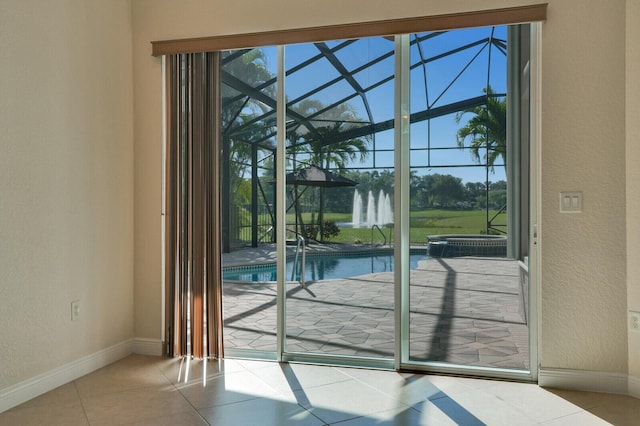 doorway to outside with tile patterned flooring, a textured wall, baseboards, and a sunroom