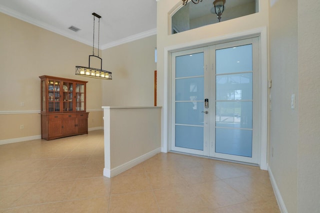 interior space with french doors, baseboards, visible vents, and crown molding