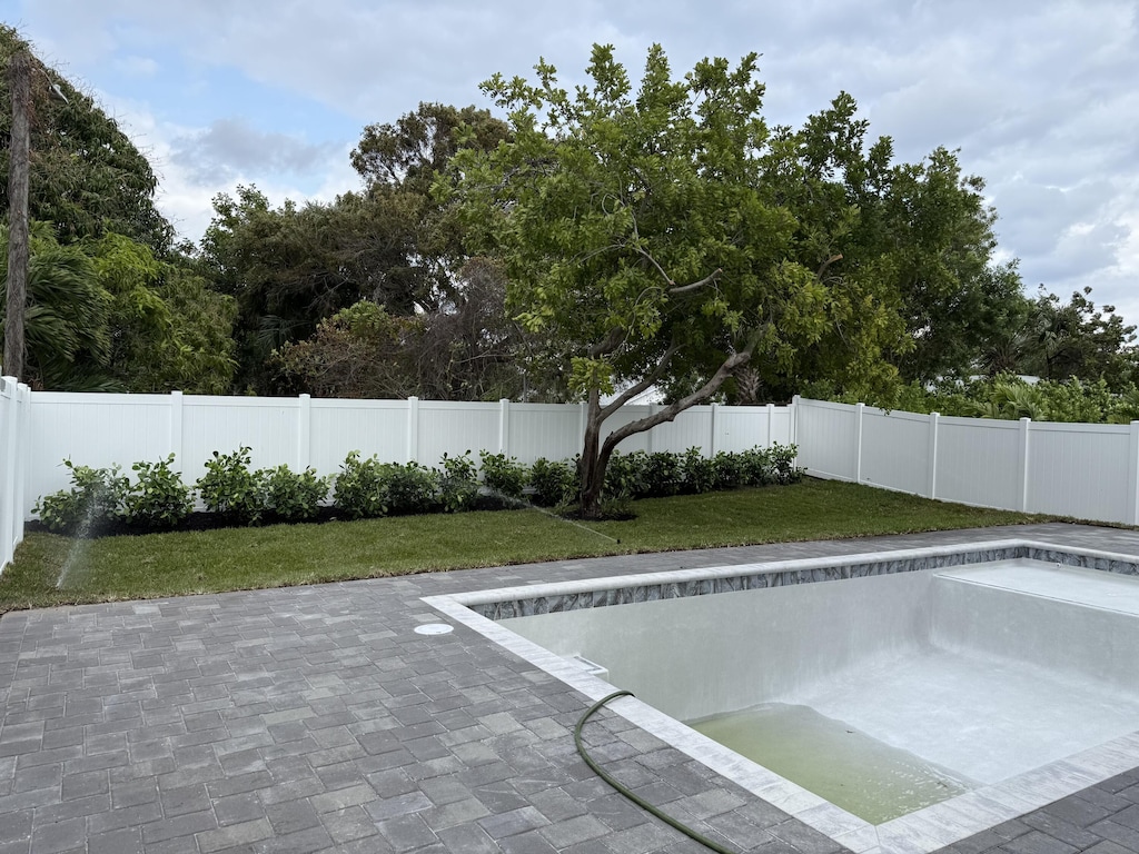 view of swimming pool with a lawn, a fenced backyard, and a patio area