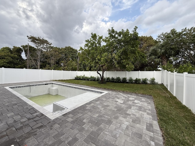 view of swimming pool featuring a yard, a fenced backyard, and a patio area