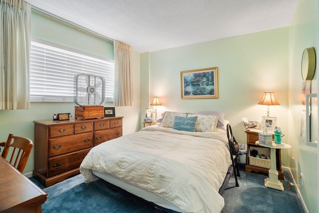 bedroom with a textured ceiling, baseboards, and dark colored carpet